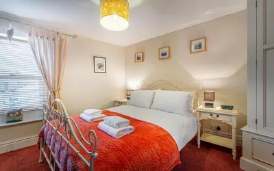 a bedroom with a bed with towels on it at Beagle Cottage in Keswick
