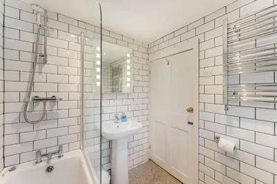 a white bathroom with a sink and a toilet at Beagle Cottage in Keswick