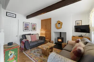 a living room with a couch and a fireplace at Darwin Cottage in Keswick
