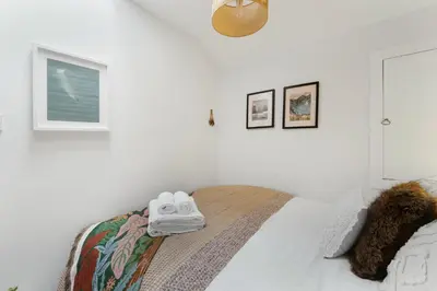 a bedroom with a bed with a pair of shoes on it at Darwin Cottage in Keswick