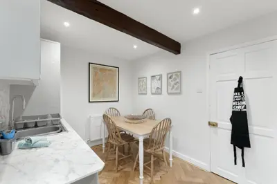 a kitchen with a table and chairs and a sink at Darwin Cottage in Keswick