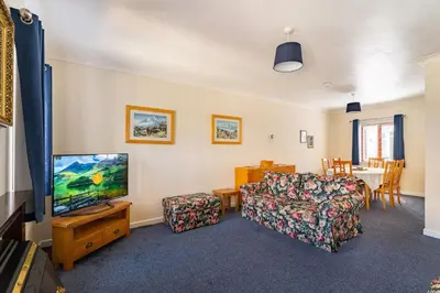 a living room with a tv and a couch at Lakeland Nook in Keswick