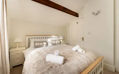 a bedroom with a large bed with towels on it at Ratstone Cottage in Keswick