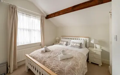 a bedroom with a large bed with two pillows on it at Ratstone Cottage in Keswick