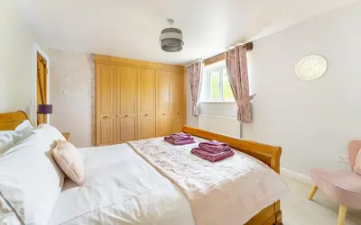 a bedroom with a white bed with purple towels on it at The Mews in Keswick
