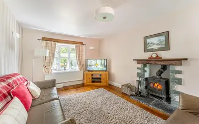 a living room with a couch and a fireplace at The Mews in Keswick