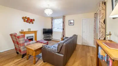 a living room with a couch and a table at Sunny Cottage in Keswick