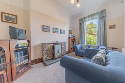 a living room with two blue couches and a fireplace at Thwaite Howe in Keswick
