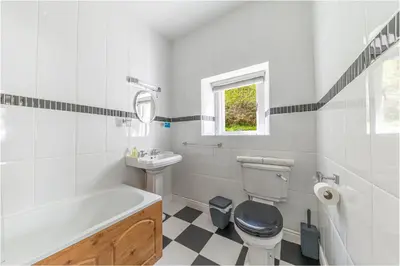 a bathroom with a tub and a toilet and a sink at Thwaite Howe in Keswick