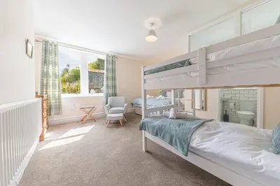a bedroom with a bunk bed and a chair at Thwaite Howe in Keswick