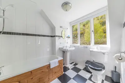 a bathroom with a tub and a toilet and a sink at Thwaite Howe in Keswick