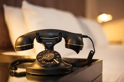 a telephone sitting on a table in a bedroom at Strathaven Hotel in Strathaven