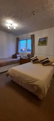 a large bedroom with two beds and a window at The White Heather Hotel in Wigton