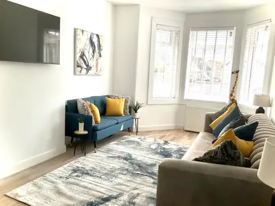 a living room with a blue couch and a rug at Harling House - Prestwick - 4 bedrooms in Prestwick