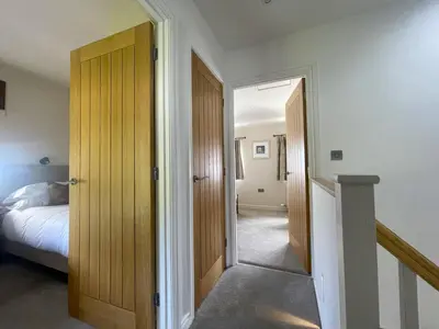 a bedroom with a bed and an open door at Glenn Cottage in Braithwaite