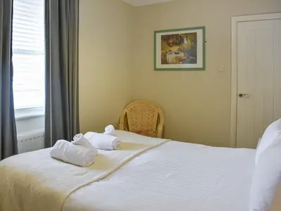 a bedroom with a bed with two towels on it at Courtyard View in Keswick