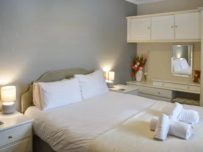 a bedroom with a large white bed with towels on it at Courtyard View in Keswick