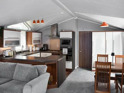 a kitchen and living room with a couch and a table at Solway Escape in Plumbland