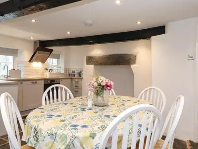 a kitchen with a table with a vase of flowers on it at One Side House Farm in Ambleside