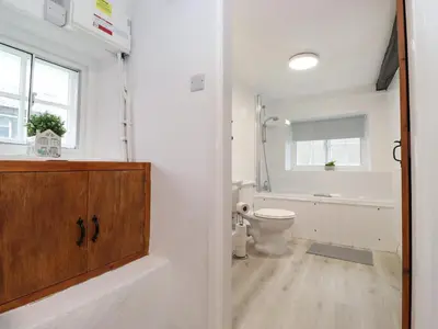 a white bathroom with a toilet and a sink at One Side House Farm in Ambleside
