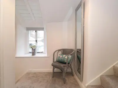 a chair in front of a mirror in a hallway at Two Side House Farm in Ambleside
