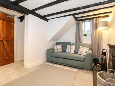 a living room with a green couch in front of a window at Two Side House Farm in Ambleside