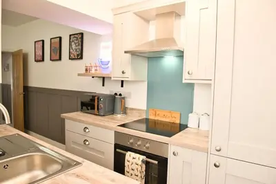a kitchen with a sink and a stove top oven at Quirky & Comfortable Residence in Workington