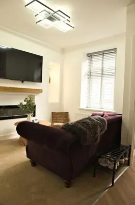 a living room with a couch and a flat screen tv at Quirky & Comfortable Residence in Workington