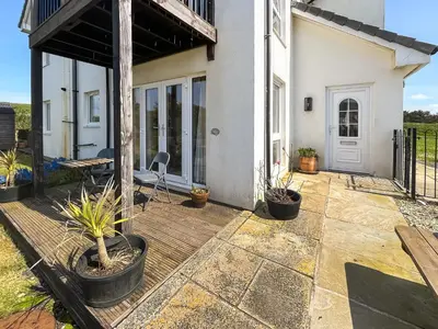 a patio with potted plants and a house at Sandpipers in Portpatrick