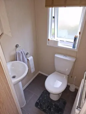 a small bathroom with a toilet and a sink at The Forest Cabin Holiday Home 15 in Ballantrae