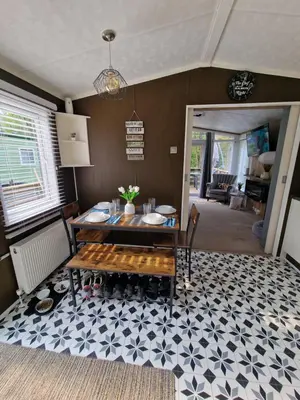 a dining room with a table and a floor at The Forest Cabin Holiday Home 15 in Ballantrae