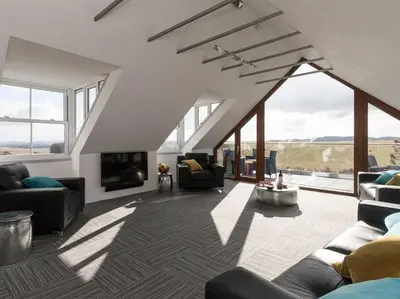 a living room with couches and a tv and windows at Cot Cottage - Panoramic Views & Hot Tub! in Castle Douglas