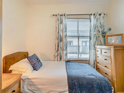 a bedroom with a bed and a dresser and a window at 2 Bed in Keswick oc-94995 in Keswick