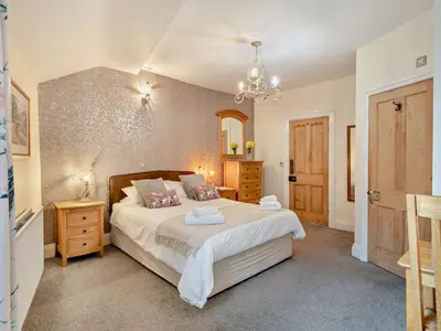 a bedroom with a large bed and a chandelier at 2 Bed in Keswick oc-94995 in Keswick