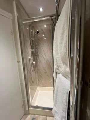 a shower with a glass door in a bathroom at Shemara rooms in Keswick