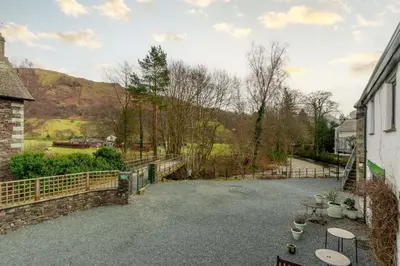 a patio with a fence and a table and chairs at Gingerbread Nook in Grasmere
