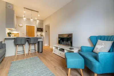 a living room with a blue couch and a table at Gingerbread Nook in Grasmere