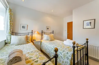 a bedroom with two beds and a window at Grey Crag Barn in Grasmere