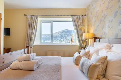 a bedroom with a large bed with a window at Grey Crag Barn in Grasmere