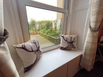 a window with two pillows on a window sill at Beautiful House With Stunning Views Kirkcudbright - Pass the Keys in Kirkcudbright
