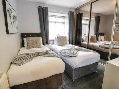 a bedroom with two beds and a mirror at Largieholm in Mauchline