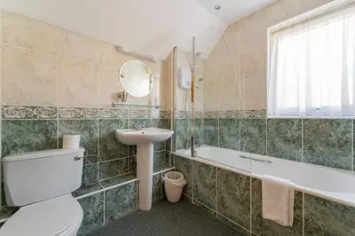 a bathroom with a toilet and a sink and a tub at Le Tholonet in Grasmere