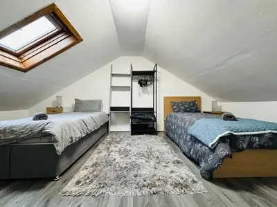 a attic bedroom with two beds and a rug at Golfers lovers! Near all famous golf courses in Prestwick