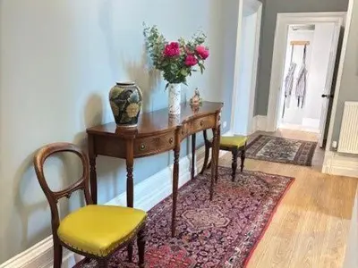 a room with a table with a vase of flowers on it at High House Cottage, Southwaite in a rural setting with garden, BBQ & hot tub in Southwaite
