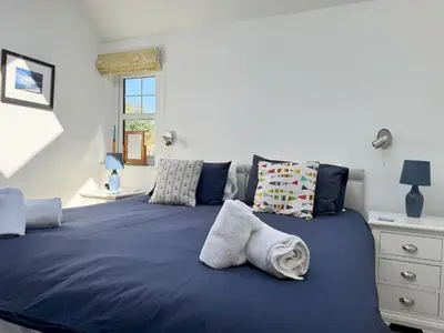 a bedroom with a blue bed with towels on it at Birds Nest in Gatehouse of Fleet