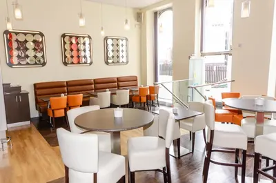 a restaurant with tables and chairs and a bench at Opul Boutique at Admiral House in Douglas