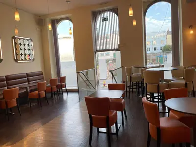 a restaurant with tables and chairs and windows at Opul Boutique at Admiral House in Douglas