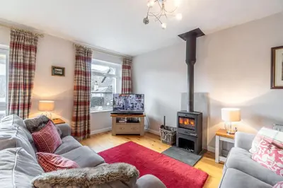 a living room with a couch and a stove at Number One in Chapel Stile