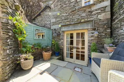 a stone building with a door and some plants at Poet's Corner in Grasmere