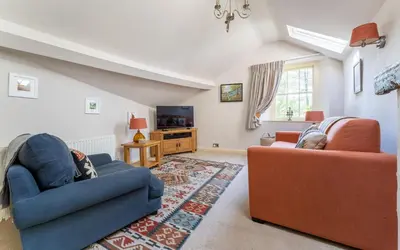 a living room with two couches and a tv at Poet's Corner in Grasmere